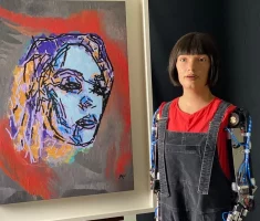 Ai-Da devant l'un des ses nombreux autoportraits © www.ai-darobot.com